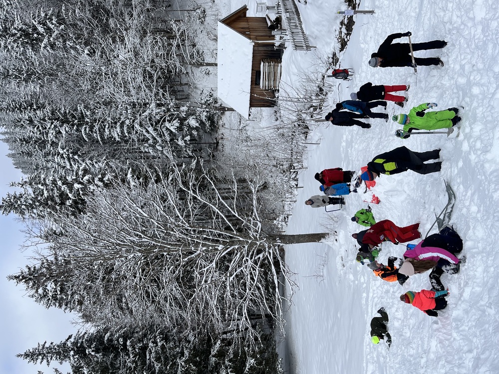 Väter und deren Kinder bauen ein Iglu